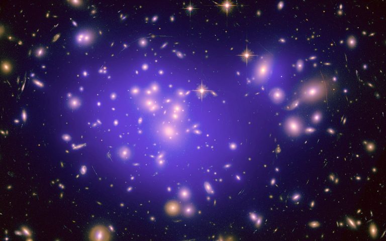 deep-space astronomical image showing a galaxy cluster with a glowing purple hue